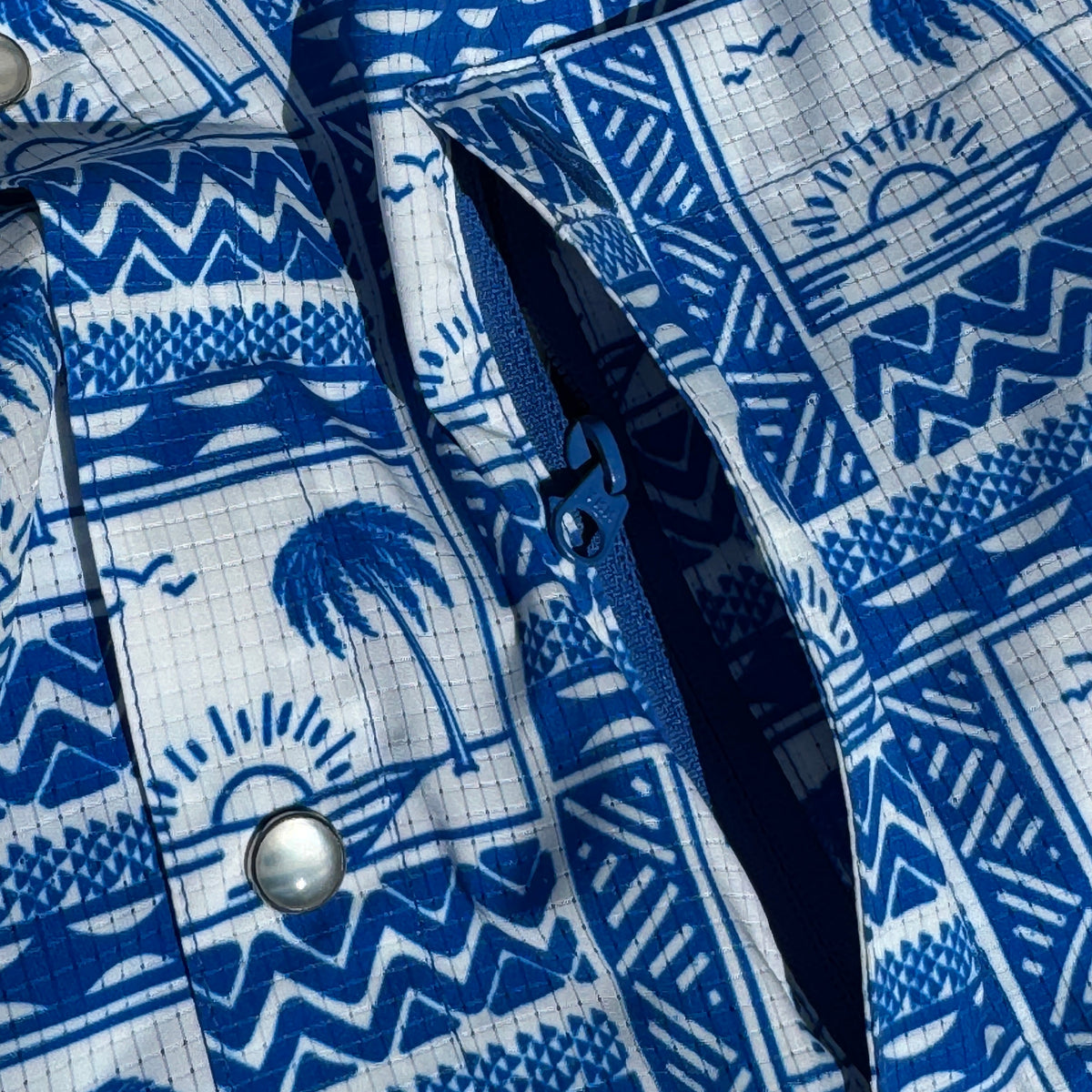 Close-up of a blue and white patterned shirt with a button.