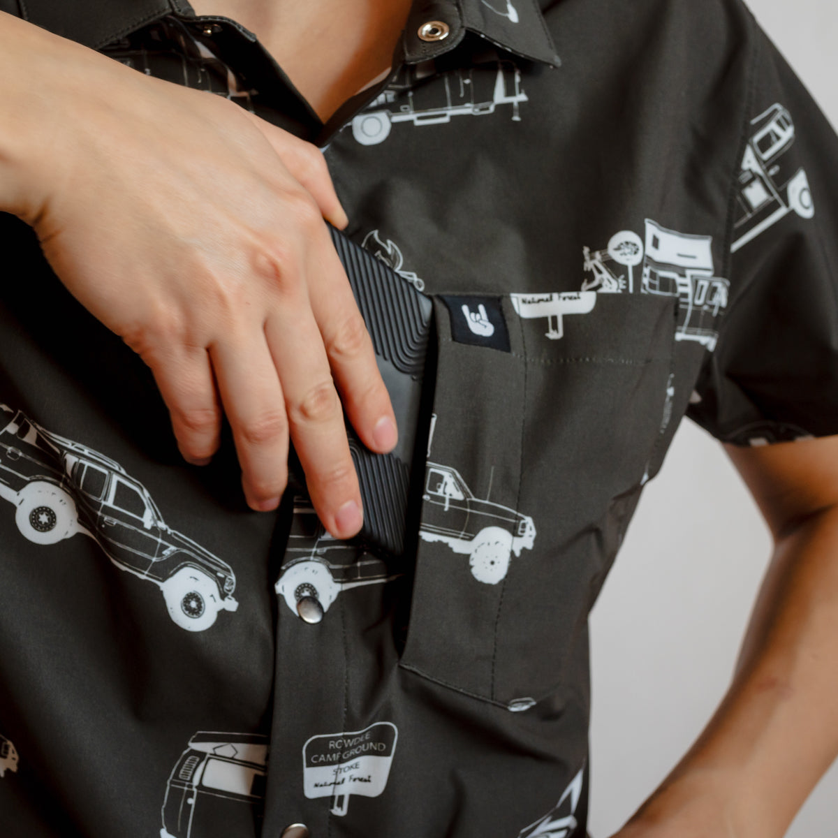 white man putting cell phone in rowdee hidden shirt pocket 